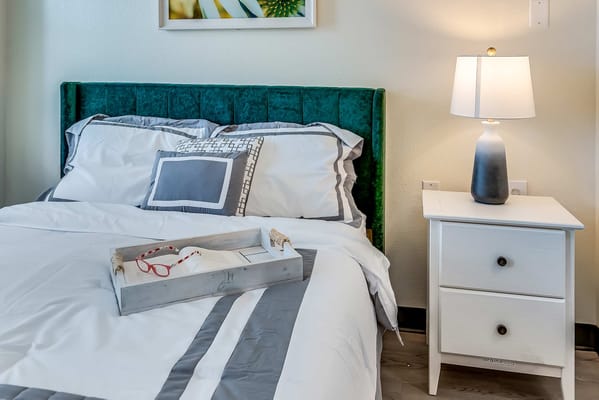 Cozy bedroom setup with a green headboard and bedside lamp