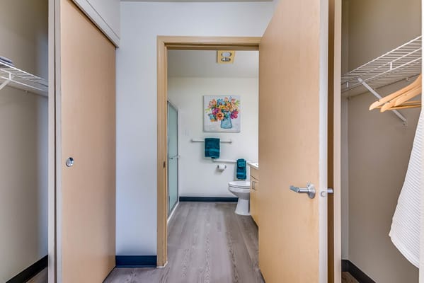 A view of a private bathroom with light decor