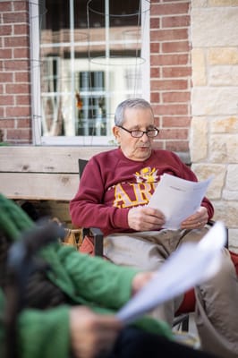 Resident reading documents in an outdoor space