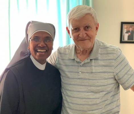 A staff member and resident smiling together indoors