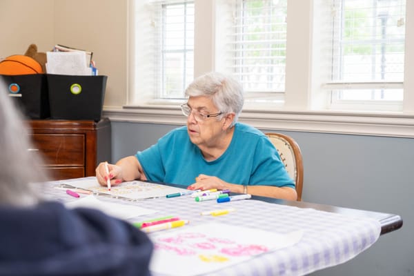 Resident engaged in arts and crafts activity indoors