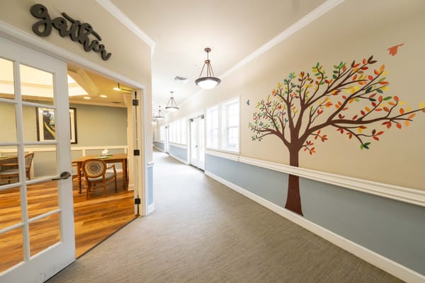 Interior hallway with decorative tree mural and seating area