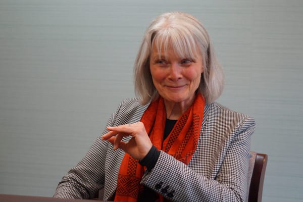 A woman in a blazer sitting at a table