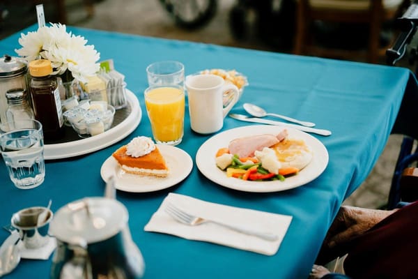 A meal served on a dining table with dessert and drink