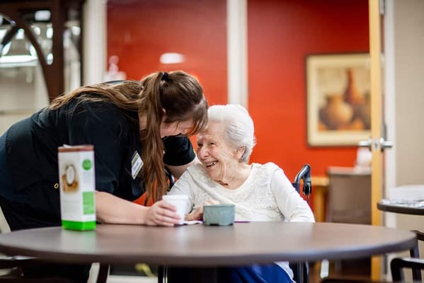 A caregiver and resident sharing a joyful moment