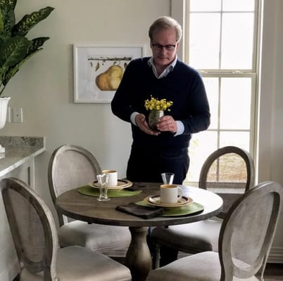 A staff member setting a dining table in a bright room