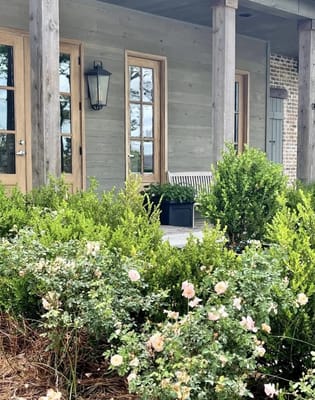 Entryway of a facility with blooming flowers and greenery