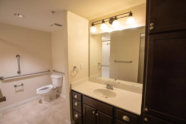 Interior view of a spacious bathroom with grab bars