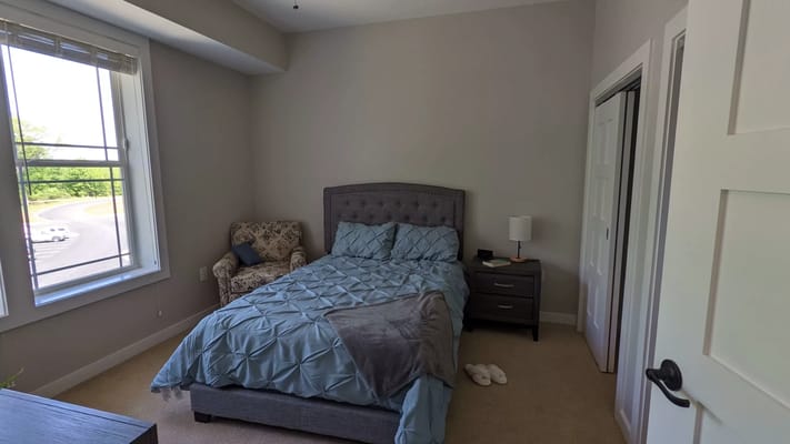 Private resident room with bed and chair