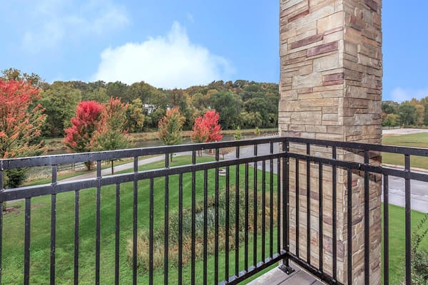 View from a balcony overlooking colorful trees and grass
