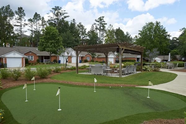 Putting green area with flags and seating in a senior living facility