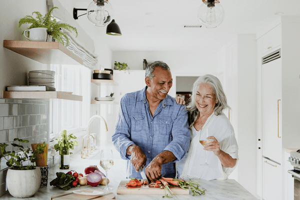Two residents preparing food together in a kitchen