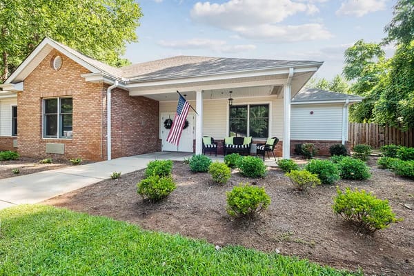 Exterior view of a senior living facility with garden