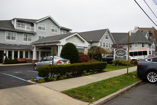 The entrance of Sunrise at Mill Basin with sign and landscaping.