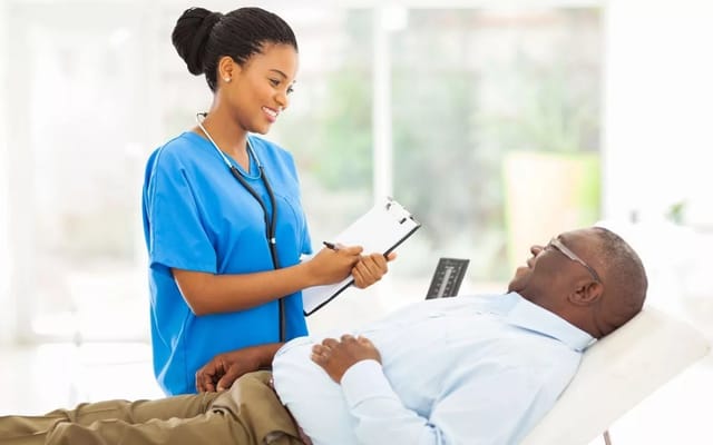 A nurse in blue scrubs consulting with a patient at St. Marie’s Hospice