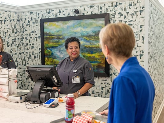 Staff member assisting a resident in a dining area