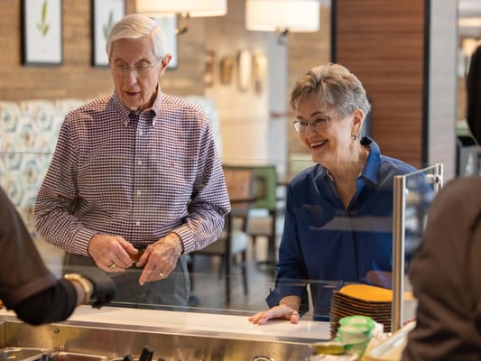Two residents enjoying a meal at the dining area