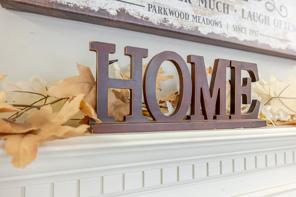 Decorative 'HOME' sign with fall leaves