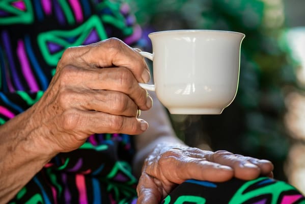 Close-up of a resident's hand holding a cup