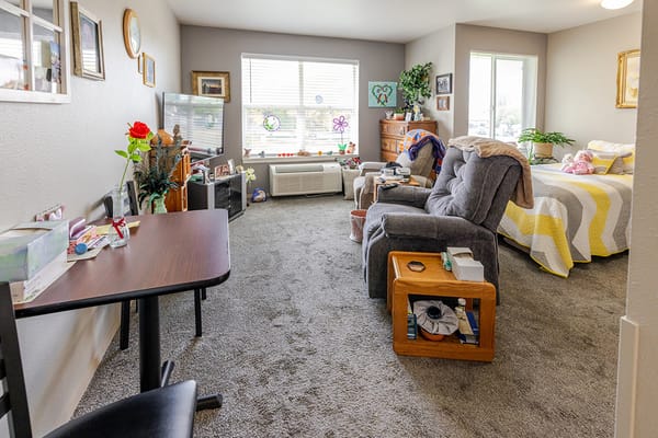 Cozy resident room with comfortable seating and personal items