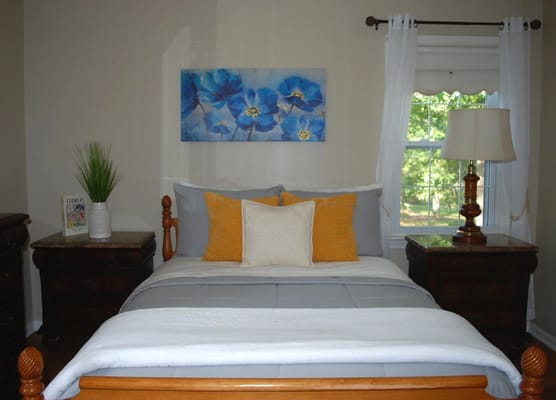 Cozy interior of a resident's bedroom with blue artwork