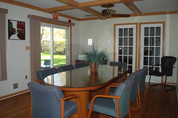 A cozy meeting room with a large table and chairs