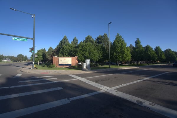 Entrance sign of The Courtyards at Mountain View surrounded by trees