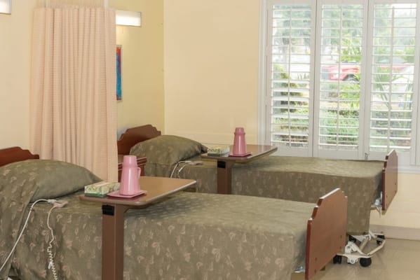 Two resident beds in a shared room with windows