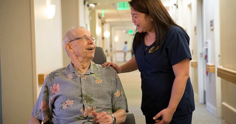 Staff member interacting with a resident in a hallway