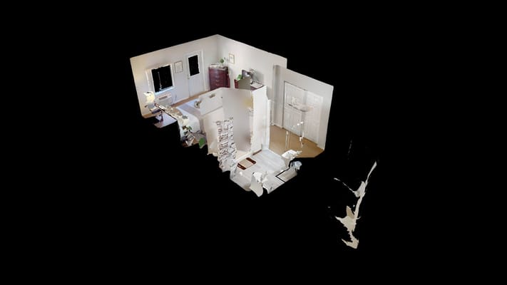 A cozy living room area with furniture and natural light.