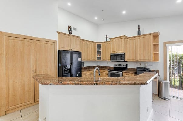Modern kitchen interior with wood cabinetry and granite countertops