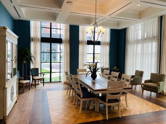 Bright common area with large windows and dining table