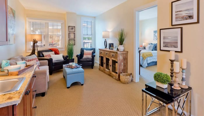 Cozy living room setup with seating, decor, and access to a bedroom.