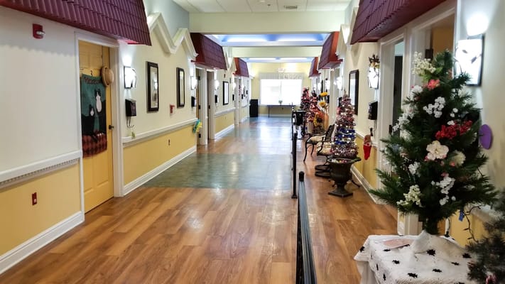 Brightly lit hallway with decorations and trees at Serra Village
