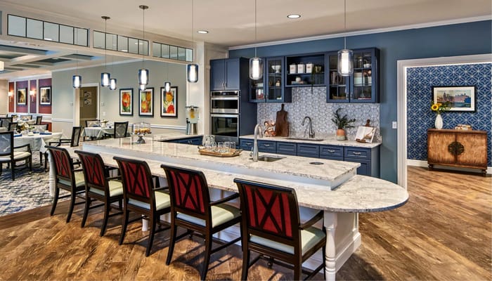 Modern kitchen with a large island and seating, featuring elegant decor.