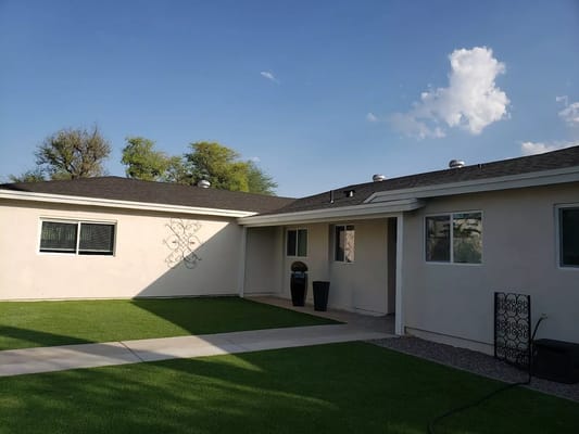 Exterior view of a single-story building with grass and path