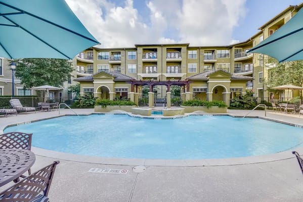 Outdoor pool area with seating and umbrellas