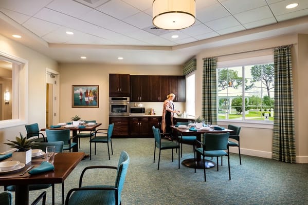 Dining area with round tables and a staff member arranging items
