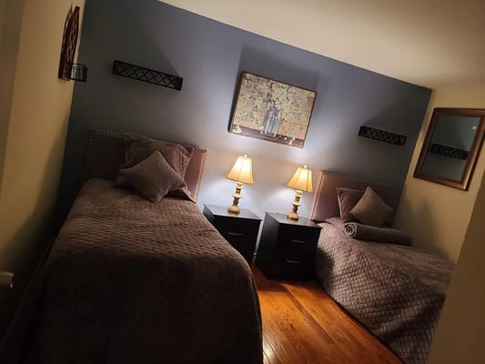 A cozy twin room setup with lamps and artwork