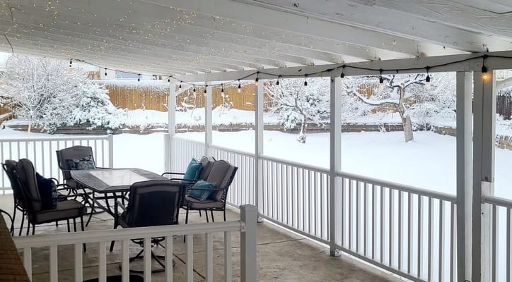Snowy outdoor patio area with seating