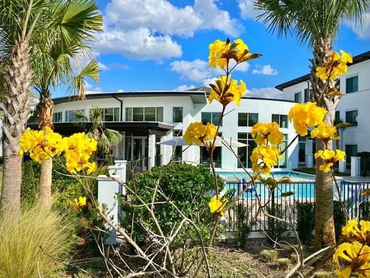 Outdoor view of facility with pool and flowers