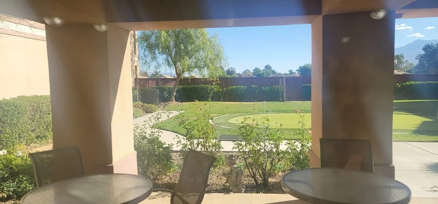 View of outdoor space with greenery and seating area