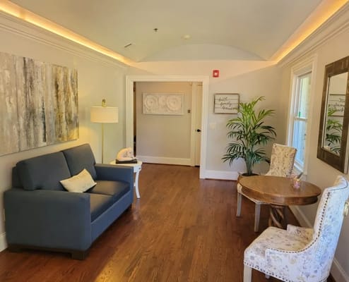 Cozy living area with a blue sofa, decorative table, and plant