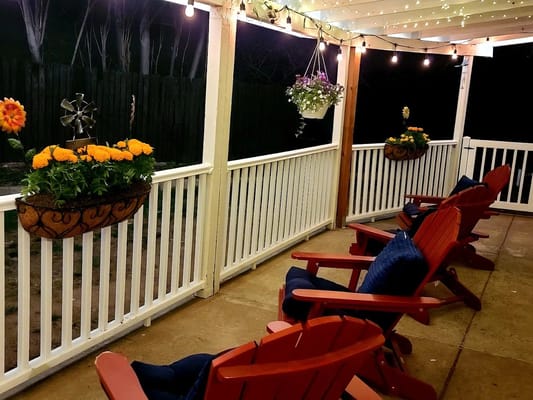 Outdoor seating area with flower baskets and lights
