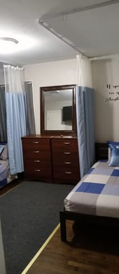 Shared bedroom featuring two beds and a dresser with a mirror