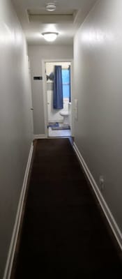 Narrow hallway leading to a bathroom.