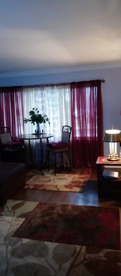A cozy living room with a table, chairs, and plants.