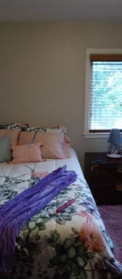 A well-decorated bedroom with floral bedding and a lamp.