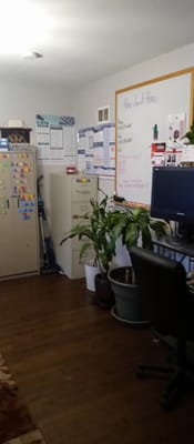 View of the office area with filing cabinets, a plant, and a computer.