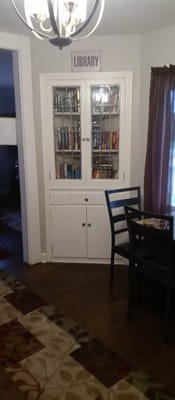 White bookshelf containing books in a library corner.